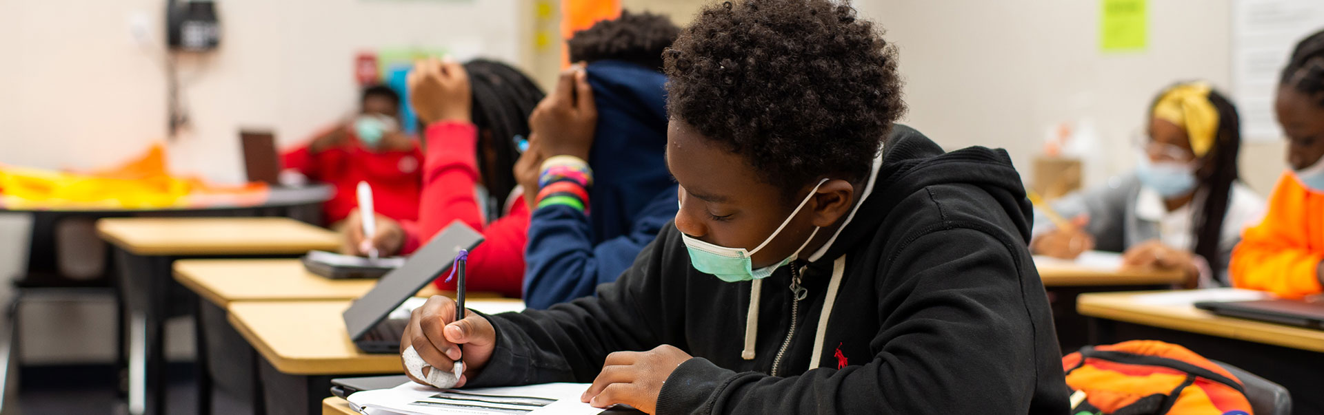 students in classroom sitting and writing