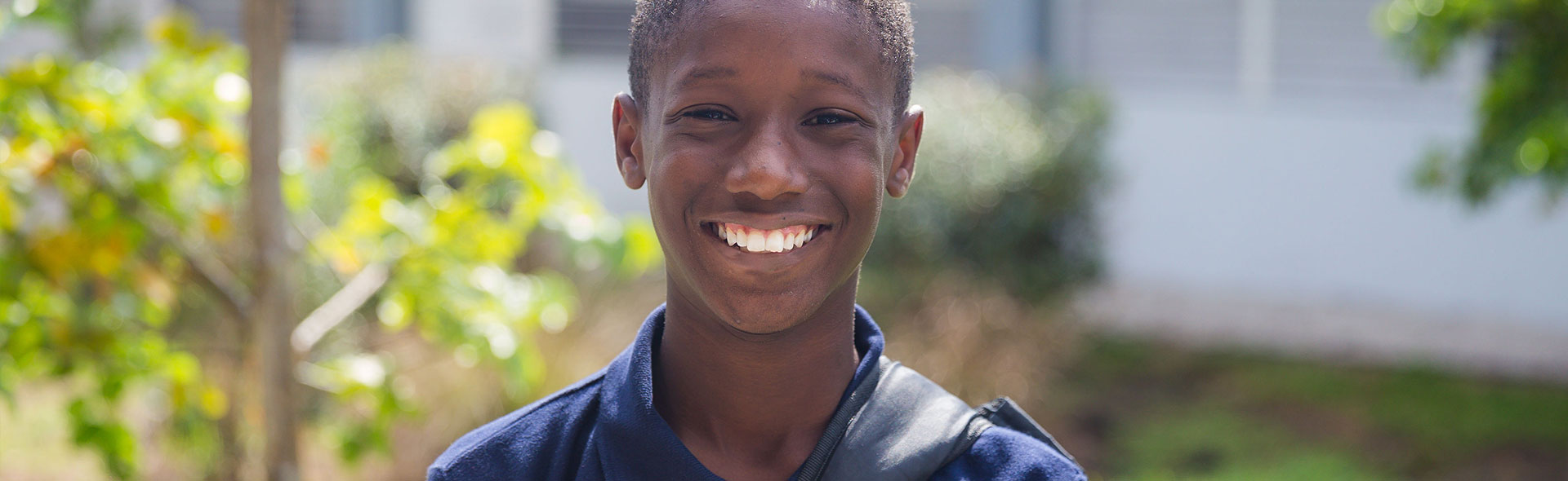 student outside of school smiling
