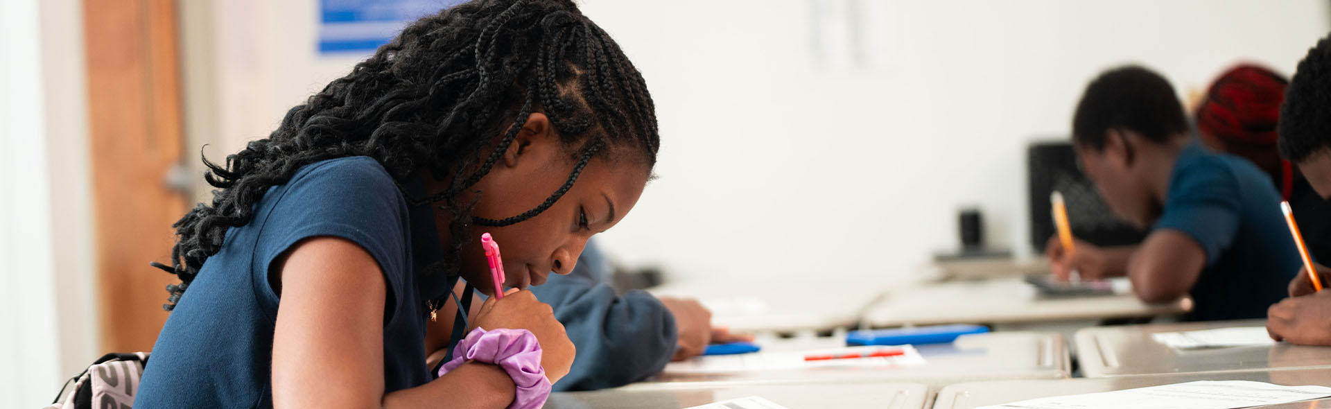 student in classroom working on assignment