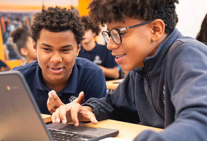 two older students looking at computer screen